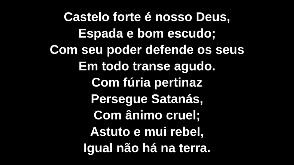 Letra do hino Castelo Forte no telão, em letras grandes brancas sobre fundo preto